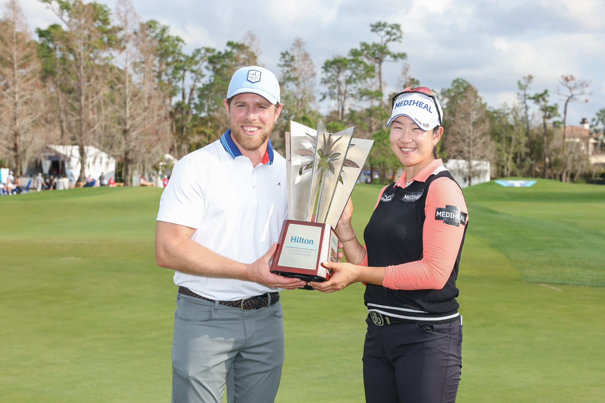 Hilton Grand Vacations Tournament of Champion A Lim Kim and celebrity champion Joe Pavelski holding trophy made by Malcolm DeMille